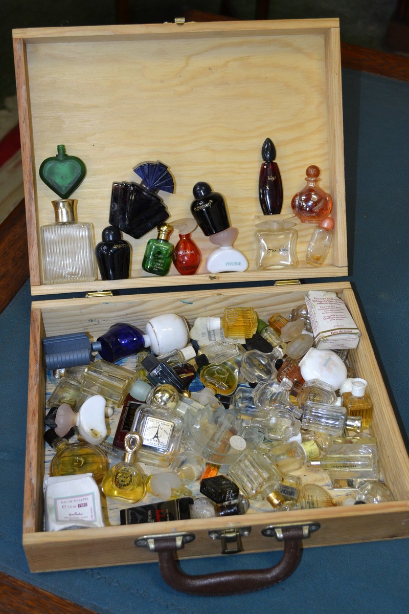 A French pine box containing perfume bottles;  'orchidee', 'cyane', 'Venise', 'Kookat', 'clarins',