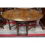 An oak drop-leaf gate leg dining table