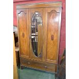 An Edwardian mahogany inlaid bedroom suit composing of a wardrobe, a bed,