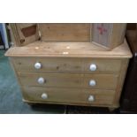 A Victorian stripped pine chest of three graduated drawers, oversailing top, ceramic handles,