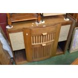 An Art Deco breakfront gramophone cabinet, hinged top, cupboard and recesses to base.