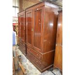 A pair of flame mahogany wardrobes, Greek key to frieze, two panelled doors over two long drawers,