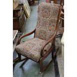 A 19th Century mahogany rocking chair, padded back, open arms with scrolling terminals,