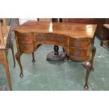 A Queen Anne style crossbanded walnut shaped serpentine desk, cabriole legs, pad feet, c.