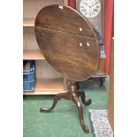 An oak tilt top tripod table, circular top, turned column, cabriole legs, pad feet.