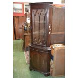 A reproduction oak floor standing corner cabinet with glazed leaded light;