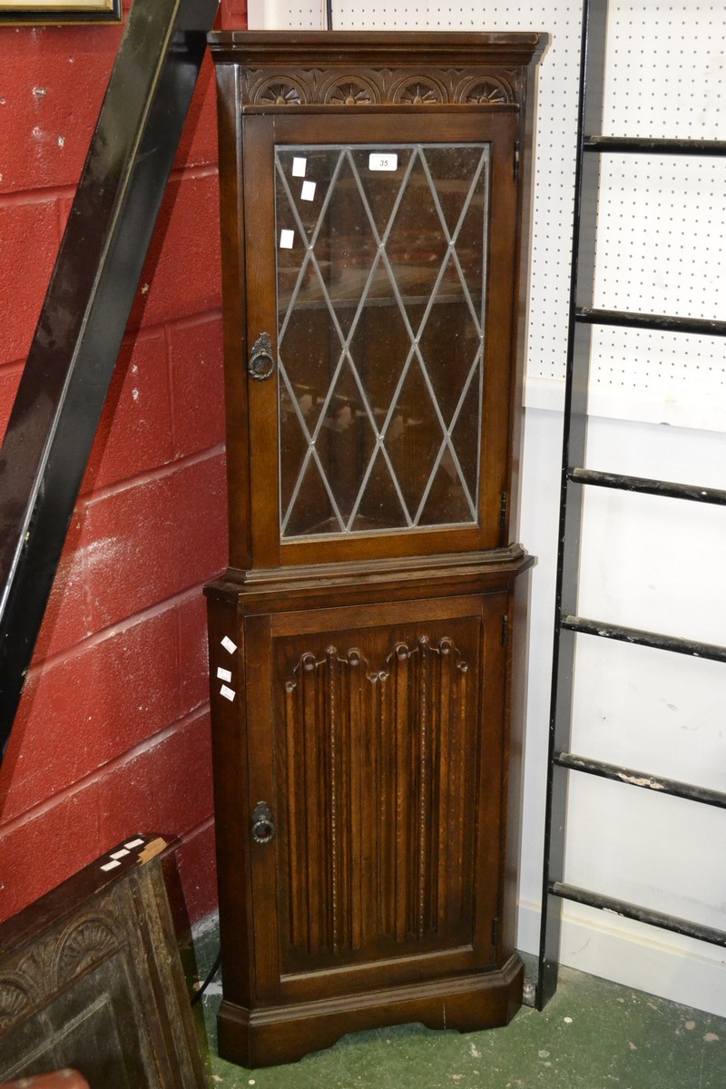 An oak floor standing corner cabinet, glazed leaded light to top,