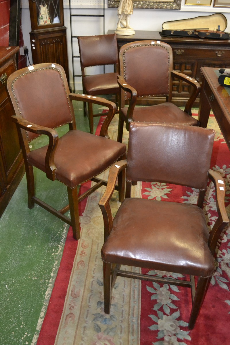 A harlequin set of four 1930/40's oak dining chairs including three carvers, padded back,