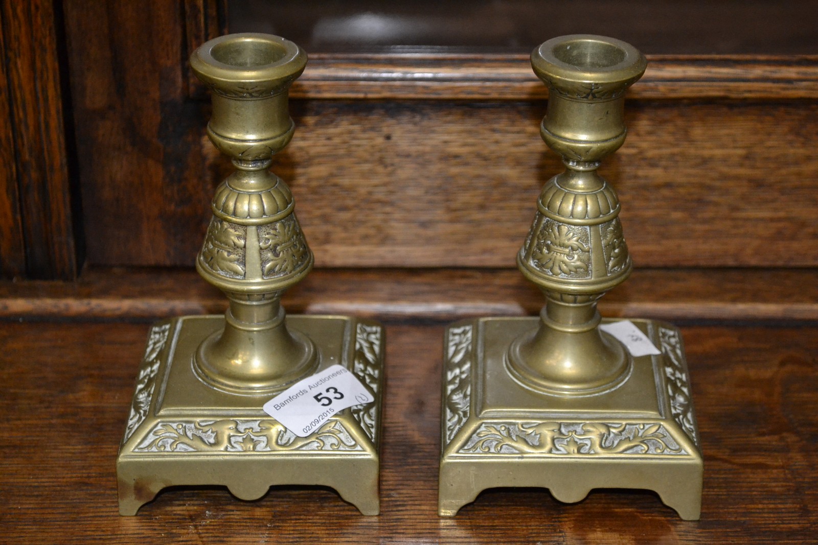 A pair of aesthetic movement brass dolphin candlesticks