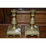 A pair of aesthetic movement brass dolphin candlesticks