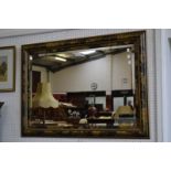 A rectangular wall mirror decorated with gilt painted leaf work designs.