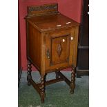 An early 20th century oak pot cupboard, carved gallery, moulded top, block fronted panel door,