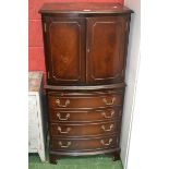 A reproduction mahogany bow front drinks cabinet, two doors to top, four graduated drawers to base,