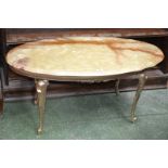 A gilt metal and onyx coffee table, scalloped oval top,