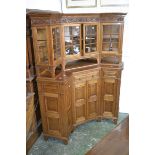 An oak corner cabinet, outswept cornice, floral carving to frieze,