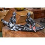 A 1950's French Polynesian plaster cast - tribal figures seated in a dugout canoe.