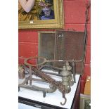 A pair of  early 20th century brass and iron andirons, an iron pot holder, a marmite hook,