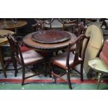 A John E Coyle circular extending dining table, gadrooned top, turned column, four legs,