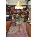 An early 20th century limed oak combination standard lamp and occasional table.