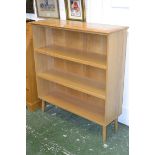 An Ercol style light oak three tier bookcase.