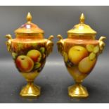 A pair of Coalport fruit lidded urns by Malcolm Hornet and Manfred Pinter