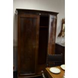 A mahogany bowfront wardrobe, stepped cornice, two panel doors, spreading bracket feet.