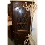 A late 20th Century corner cabinet, astral glazed door to top, linen fold  panelled door to base .