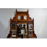 An Edwardian mahogany over mantel, two shaped mirrors above beveled edge rectangular mirrors,