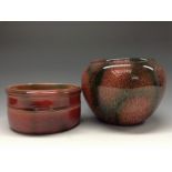 A Bretby Granite flared circular planter, glazed with green inclusions on a mottled red ground,