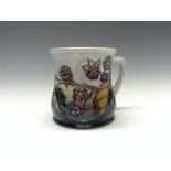 A contemporary Moorcroft Blackberry mug, tube lined with berries and leaves, in autumn tones,  8.