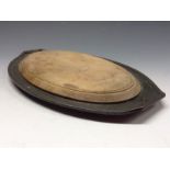 A Period Pewter hammered oval stand and  bread board, geometrical handles, 34cm wide, shape no.