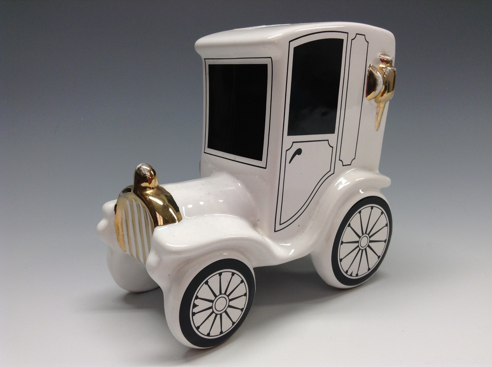 A Bretby novelty motor car money box, coin aperture, rubber stopper, white glaze,