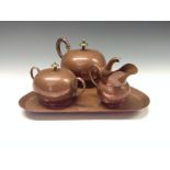 An Arts and Craft  copper tea service, comprising a bullet shaped teapot, milk jug,