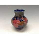 A Moorcroft Pomegranate pattern vase, tube lined with large flowerheads adn berries in red,