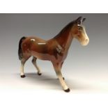 A Bretby model of a horse, glazed in tones of brown with dappled grey and white legs, 15cm high,