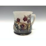 A contemporary Moorcroft Blackberry mug, tube lined with berries and leaves, in autumn tones,  8.