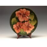 A Moorcroft Hibiscus pattern circular plate, tube lined with large flowerheads and foliage,