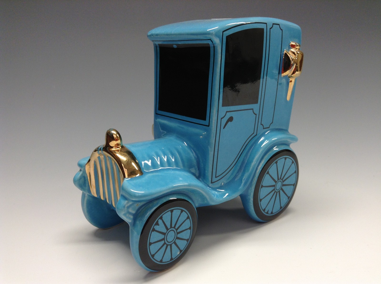 A Bretby novelty motor car money box, coin aperture, rubber stopper, blue glaze,