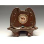 A Bretby Art Nouveau shaped cartouche timepiece, planished and copper glaze,
