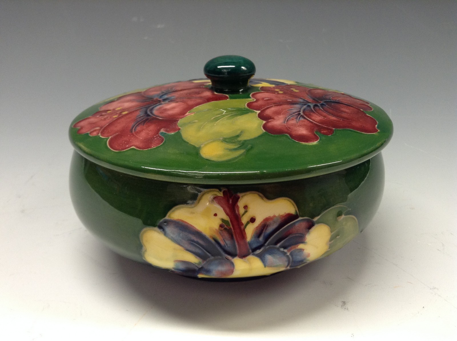 A Moorcroft Hibiscus pattern powder bowl and cover, tube lined with large flowerheads in red,