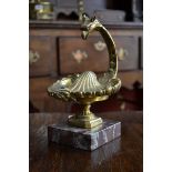 A 19th century gilt bronze desk well, cast as a griffin mask above a shell, hinged cover,