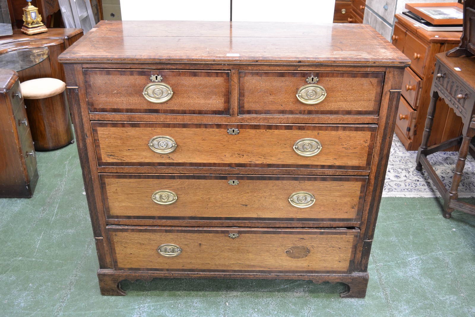 A George III mahogany crossbanded oak chest of two short and three long graduated cockbeaded