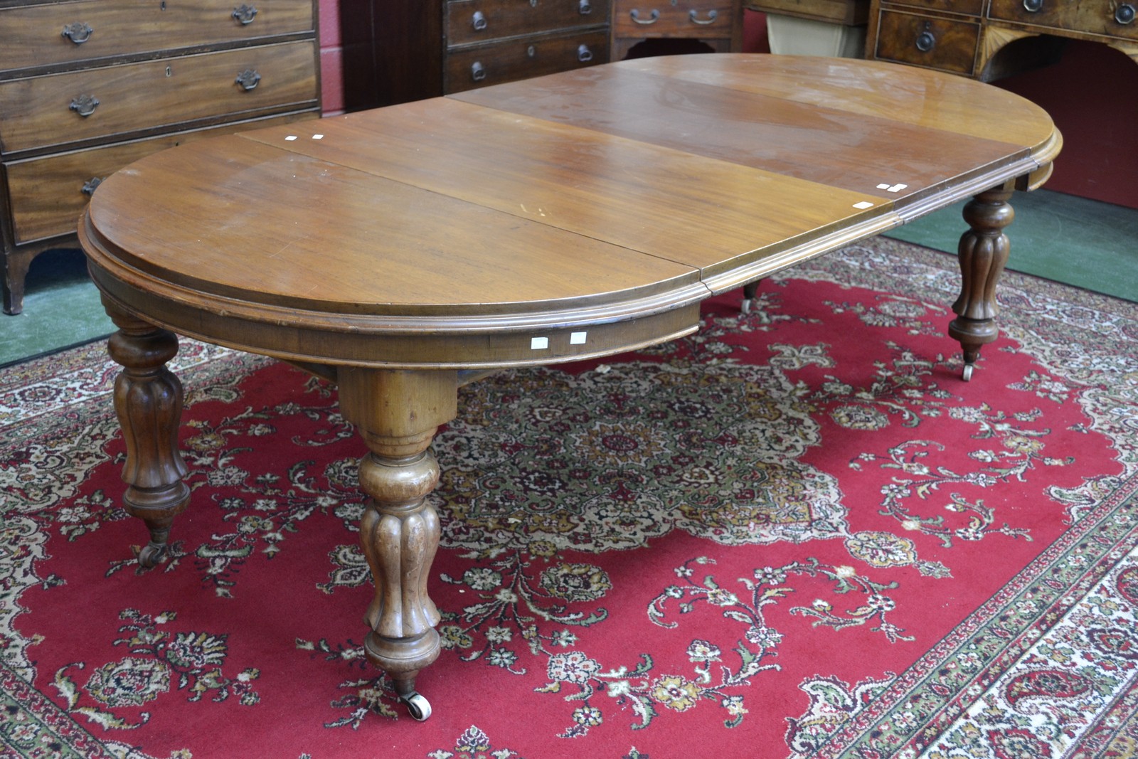 A Victorian mahogany pull-out dining table, with two additional leaves,