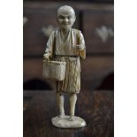 A Japanese ivory okimono, of a fisherman, standing holding a basket, 15cm high, signed,