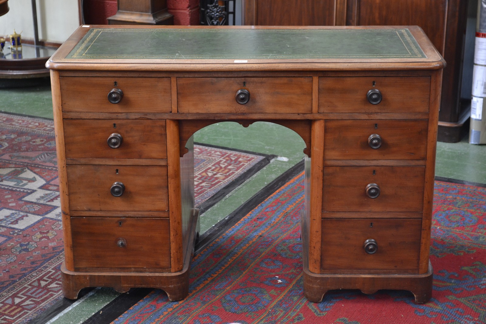 A Victorian kneehole desk, tooled inlaid green leather top,