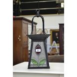 A wrought iron and stained glass porch lantern.