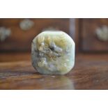 A Chinese jade canted square seal, carved in relief with a dragon amongst scrolling clouds,