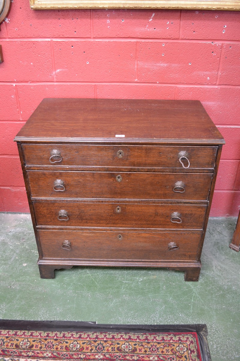 A George III oak chest of two short and three long graduated drawers,