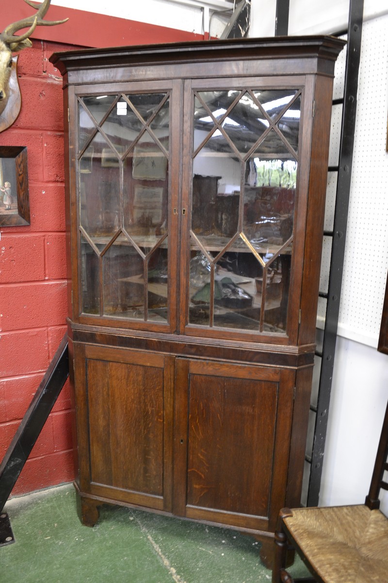 A George III oak and mahogany splay fronted floor standing corner cupboard,