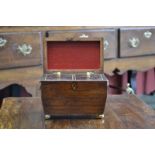 A George IV rosewood sarcophagus tea caddy, hinged cover enclosing a pair of lidded compartments,